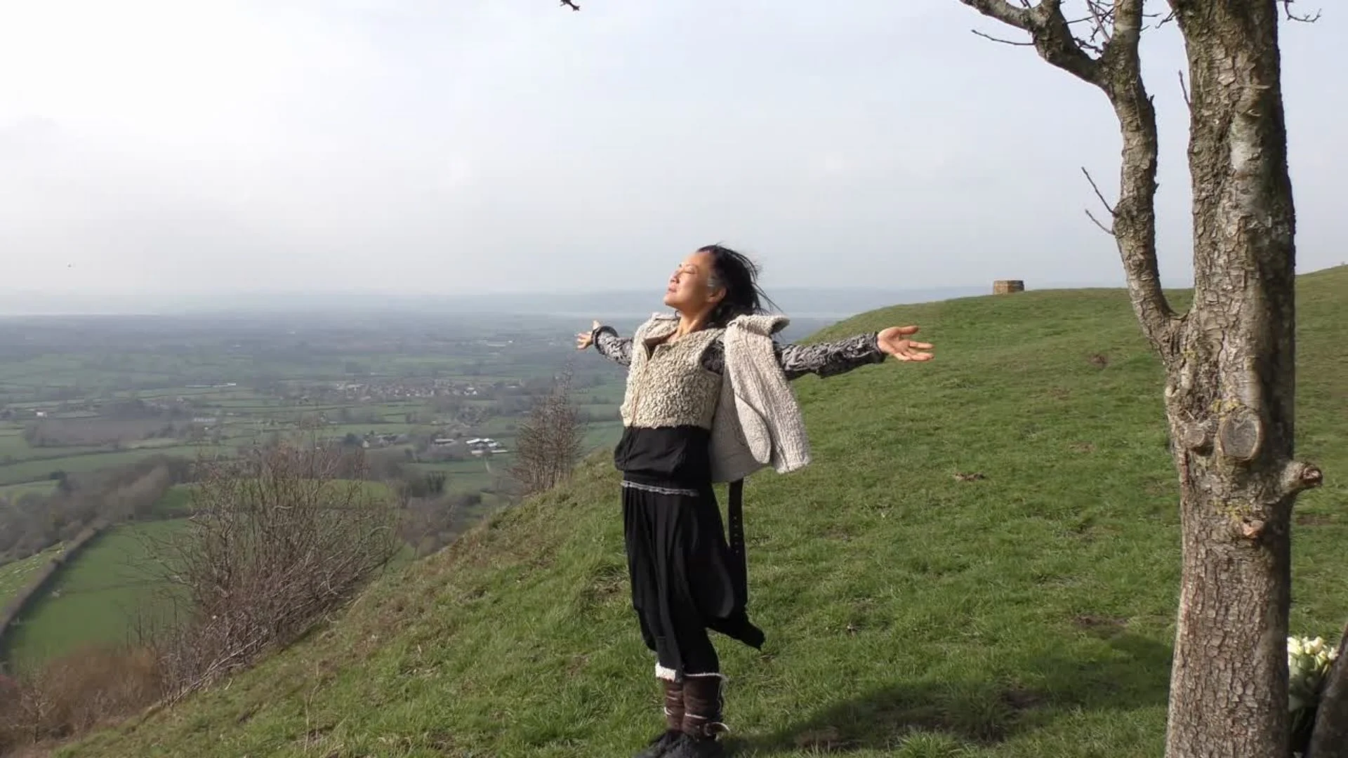 Helene Su standing with arms open on a hillside" · Caption: "Helene Su · Niio Dance"